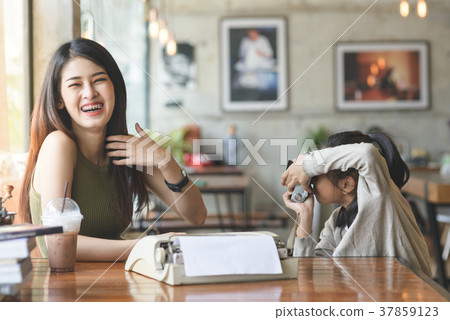 Cute young girl taking a photo of her sister 37859123