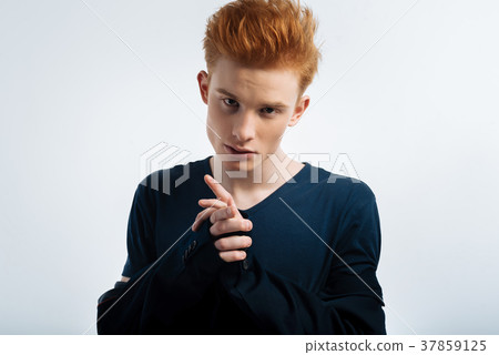 Preoccupied young man taking his jacket off 37859125