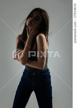 Pretty unsmiling woman touching her neck 37859634