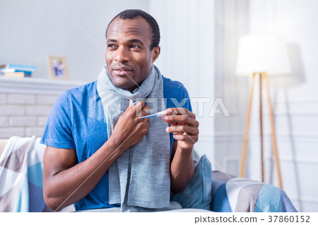Nice cheerless man holding a thermometer Nice cheerless man holding a thermometer 37860152