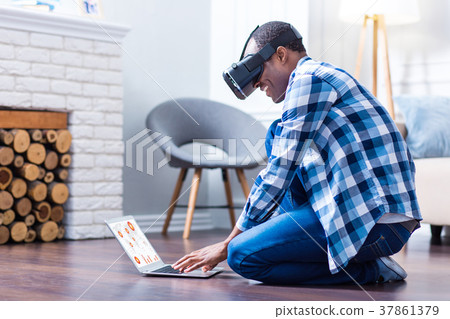 Cheerful positive man typing on a laptop Cheerful positive man typing on a laptop 37861379