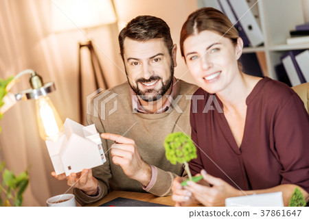Cheerful male person pointing at model of building 37861647