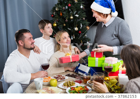 Elderly woman giving Christmas presents to family Elderly woman giving Christmas presents to family 37862153