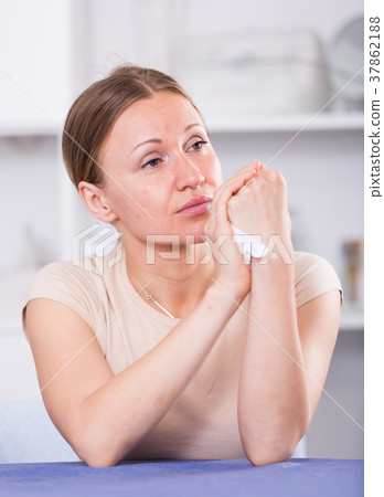 Upset woman sitting at table 37862188
