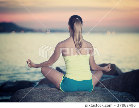 Positive sportwoman meditating in yoga padmasana 37862496
