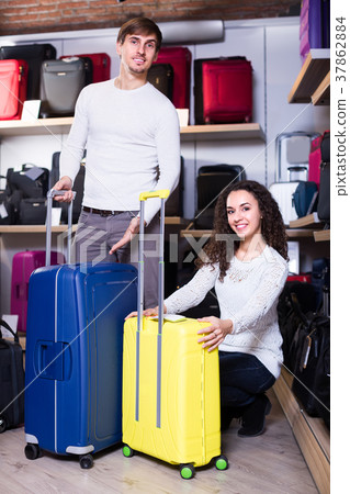 Couple choosing travel suitcase in shop. 37862884