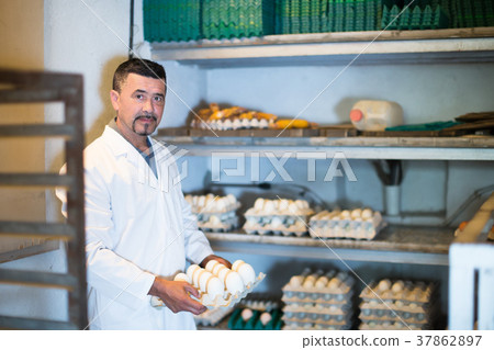 Young man working and packing white hen eggs 37862897