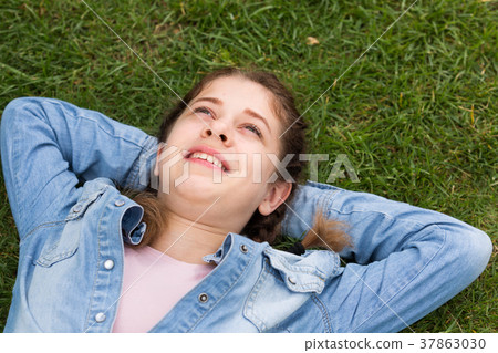 portrait of teenager while lying in summer green park portrait of teenager while lying in summer green park 37863030