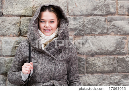 teenager girl in hood near wall teenager girl in hood near wall 37863033