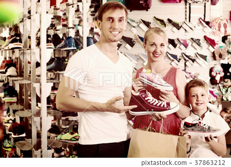 Family choosing shoes in sport shop. 37863212