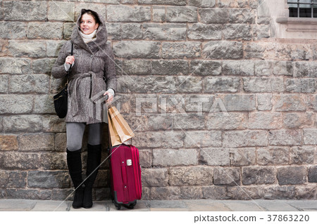 cheerful female with baggage near wall cheerful female with baggage near wall 37863220