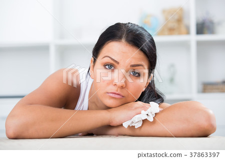 Sad brunette wipes tears 37863397