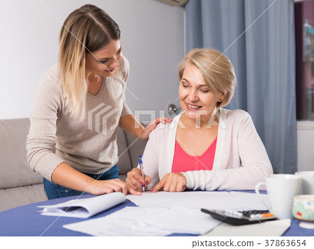 Daughter helps mother to lead home accounting Daughter helps mother to lead home accounting 37863654