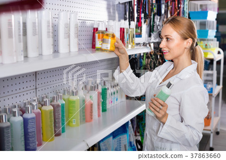 Young woman seller showing types of pet shampoo 37863660