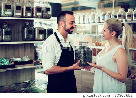 Seller and customer in store of ecological goods.] 37863692