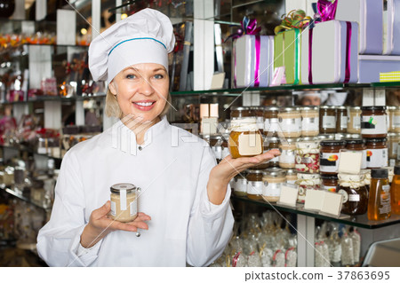 Saleswoman with sweets in jars. Saleswoman with sweets in jars. 37863695