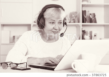 Mature woman communicates via the Internet 37863725