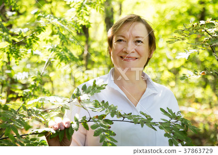 Woman standing in summer in wood Woman standing in summer in wood 37863729