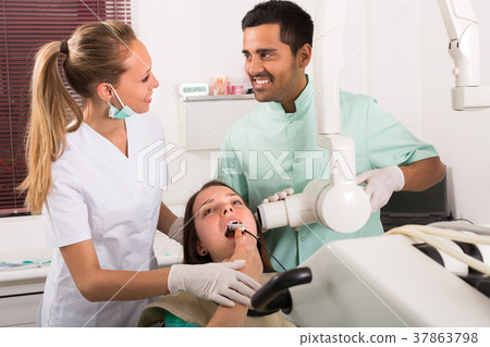 Dentist examines patient at clinic 37863798