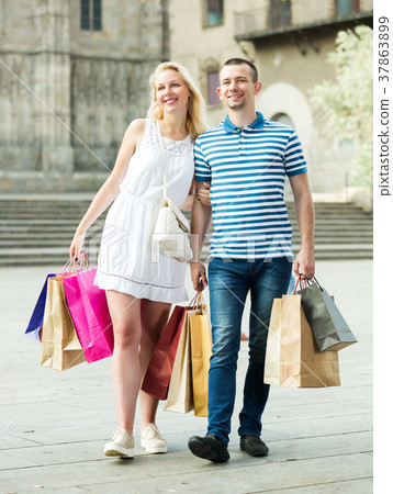 Couple with many bags outdoors 37863899