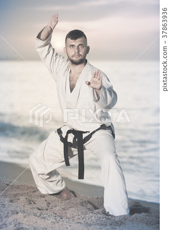 Ordinary male doing karate at ocean quay 37863936