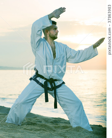 Young sportsman is training the Kokutsu-dachi stance Young sportsman is training the Kokutsu-dachi stance 37863983