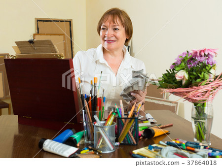Elderly woman painting for fun at home Elderly woman painting for fun at home 37864018