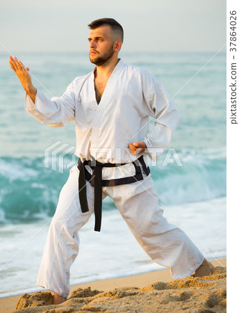 Sportsman is exercising to doing the Kokutsu-dachi stance Sportsman is exercising to doing the Kokutsu-dachi stance 37864026