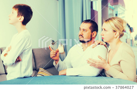 Serious woman with man parenting son Serious woman with man parenting son 37864027