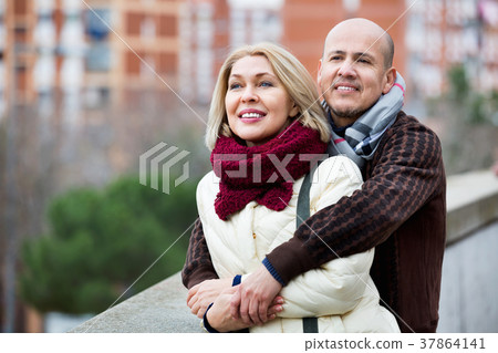 Portrait of pleasant smiling mature couple in city Portrait of pleasant smiling mature couple in city 37864141