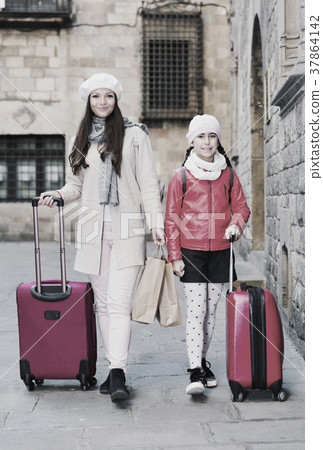 woman with daughter walking with bags woman with daughter walking with bags 37864142