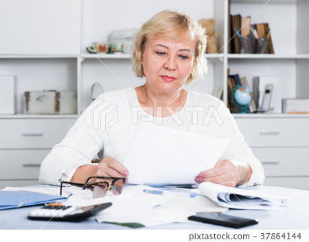 Woman engaged in home accounting Woman engaged in home accounting 37864144