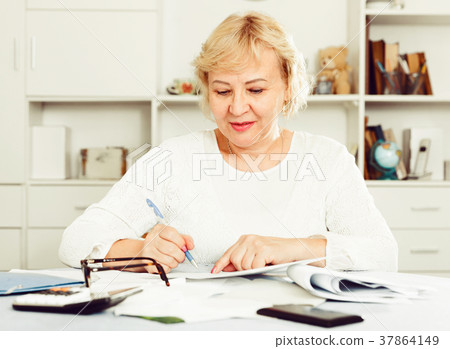 Woman engaged in home accounting Woman engaged in home accounting 37864149