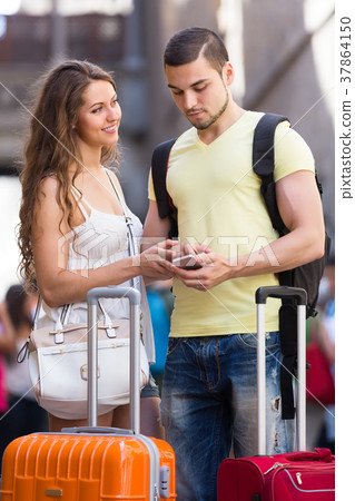 Couple with GPS navigator and baggage Couple with GPS navigator and baggage 37864150