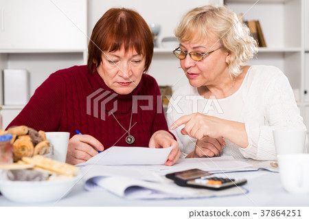 Worried mature female friends with papers Worried mature female friends with papers 37864251