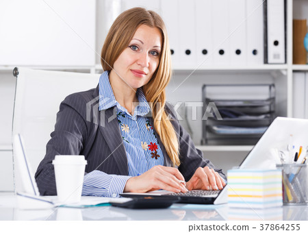 Serious businesswoman working in office Serious businesswoman working in office 37864255