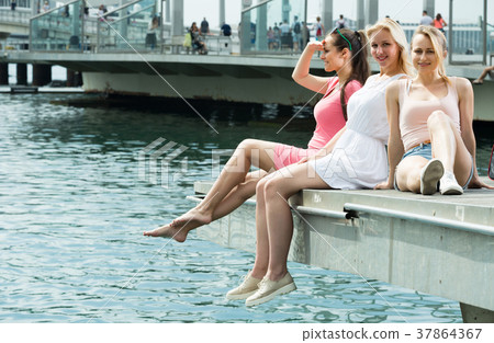 women resting on esplanade 37864367