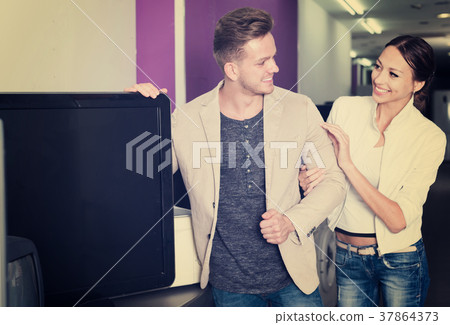 Young couple purchasing flat screen television set Young couple purchasing flat screen television set 37864373