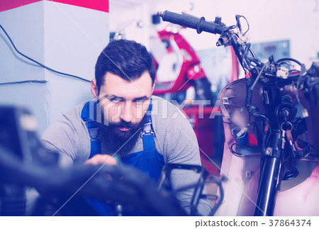 Worker repairing motorbike Worker repairing motorbike 37864374