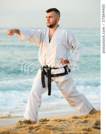 Smiling male practising karate kata poses 37864400