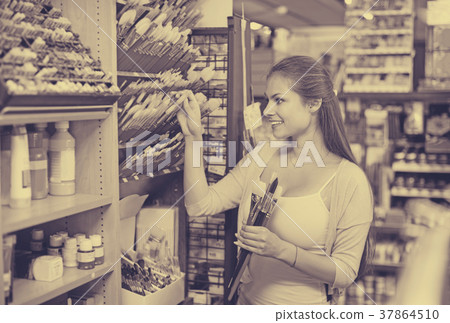 Portrait of cheerful woman choosing brushes for drawing Portrait of cheerful woman choosing brushes for drawing 37864510