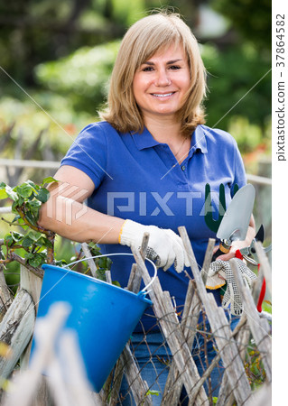 mature woman with tools in garden. 37864582