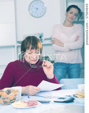 Young woman and mother with financial documents, quarrel Young woman and mother with financial documents, quarrel 37864649