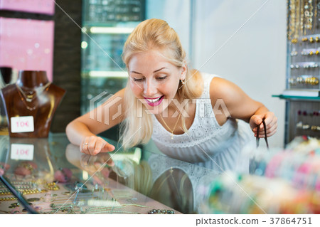 Portrait of young woman standing next to glass showcases 37864751