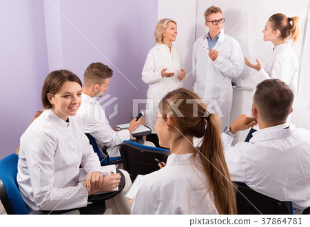 Medical students communicating during recess between lectures in auditorium 37864781