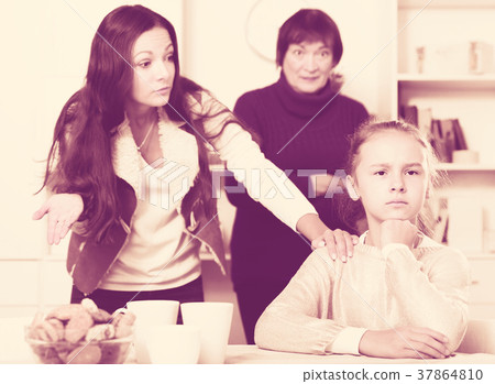 Upset girl scolded by mother and grandma Upset girl scolded by mother and grandma 37864810