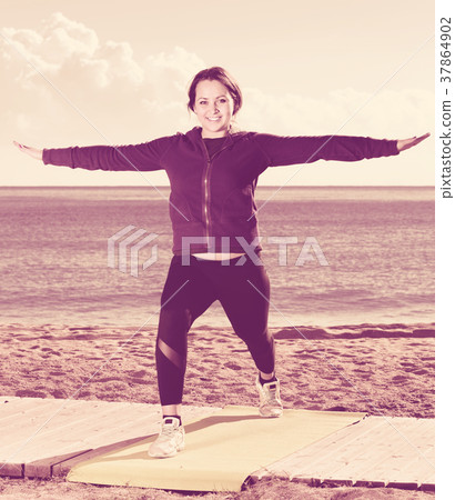 Young woman doing youga at beach 37864902