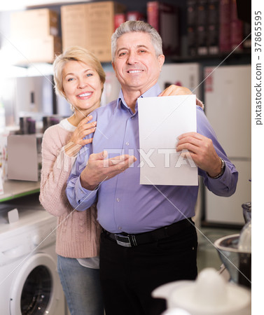 Charming mature couple buying on credit agreement for home appliances 37865595