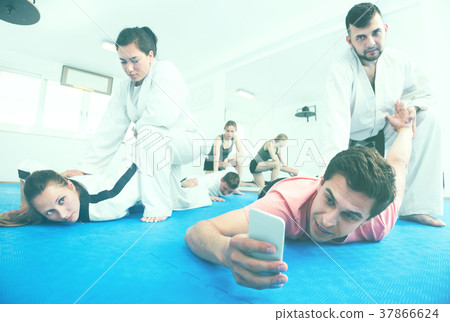 Adults taking photos while practicing taekwondo holds 37866624