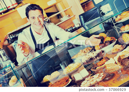Positive smiling cafe staff offering fancy and sponge cakes Positive smiling cafe staff offering fancy and sponge cakes 37866929
